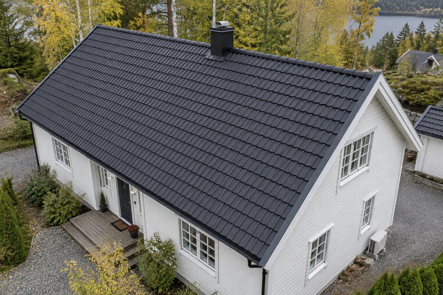 Mørkt saltak på et hvitt trehus, sett skrått ovenfra.