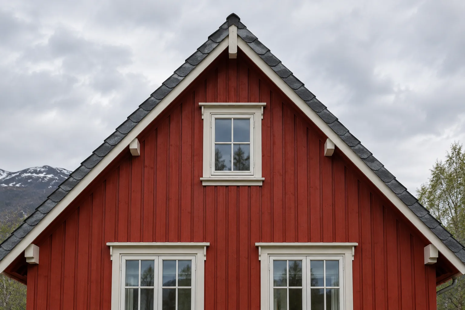 Fronten av et rødt trehus med et tydelig trekantet saltak.